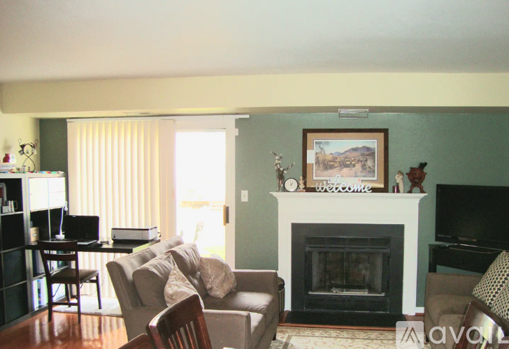 A living room with a fireplace and a painting on the wall.
