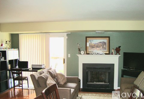 A living room with a fireplace and a painting on the wall.