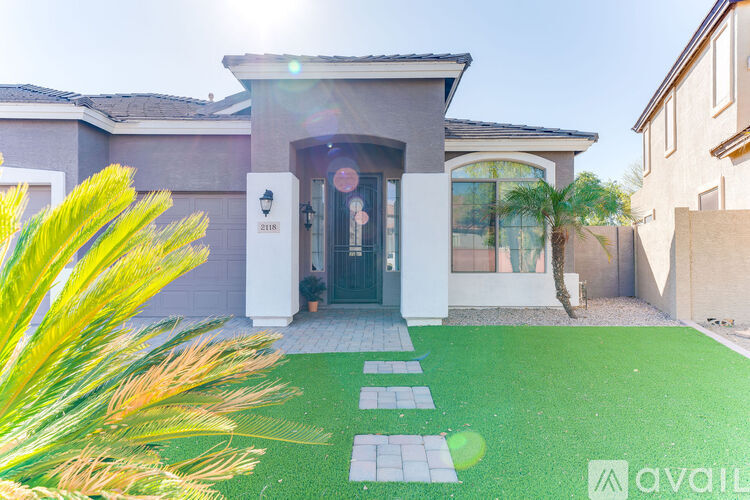 A house with a green lawn in front of it.