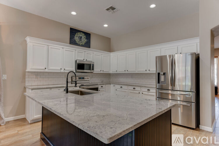 A kitchen with a marble countertop and stainless steel appliances.