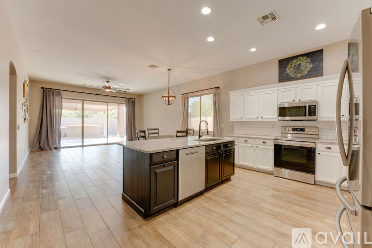 A modern kitchen with a large island and stainless steel appliances.
