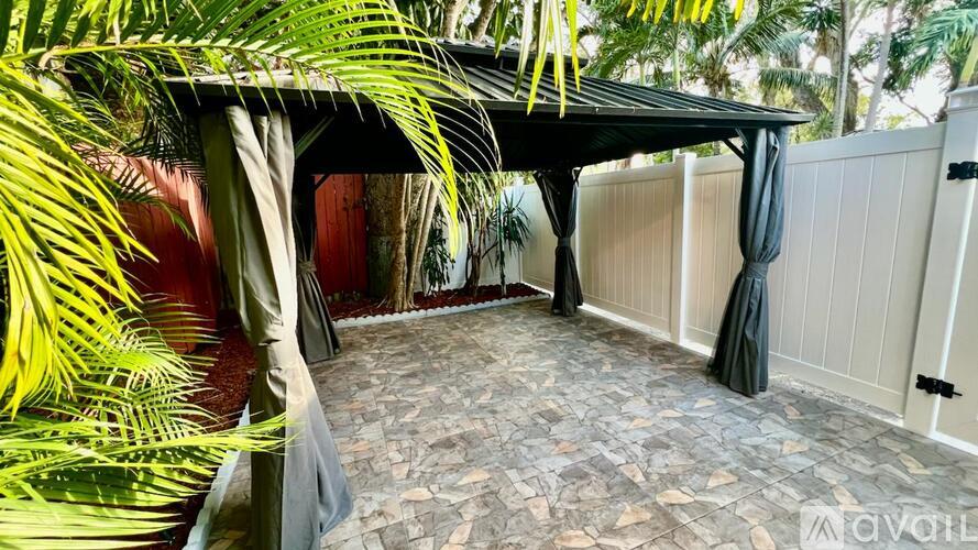 A patio area with a black canopy and a stone floor.