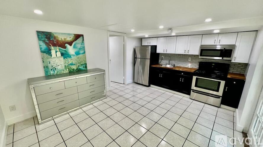 A kitchen with a refrigerator, oven, and microwave.