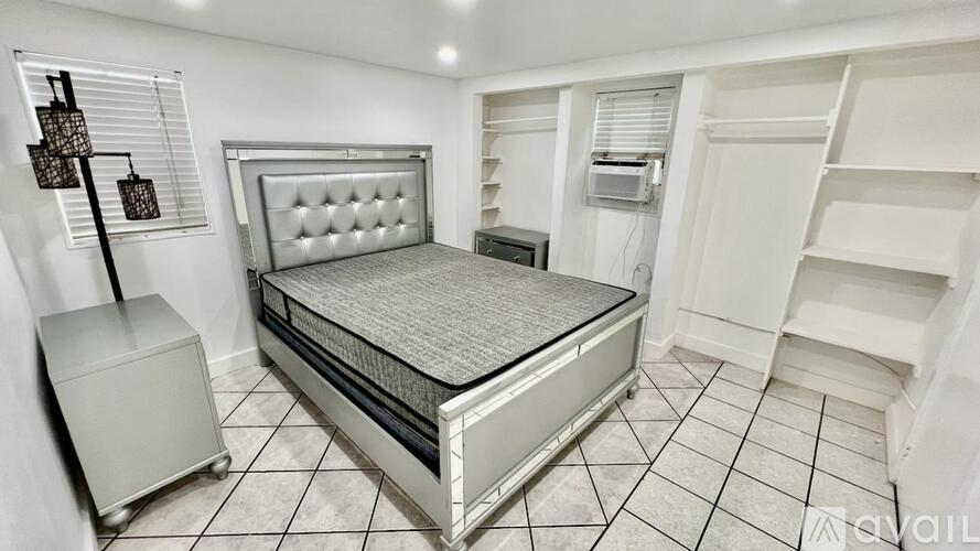A bedroom with a bed, nightstand, and a cabinet.