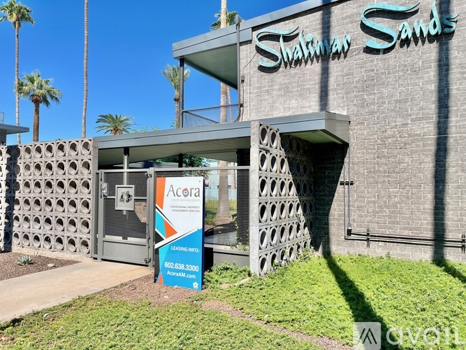 A sign for Acora Excavating is in front of a building with the name Shamrock Sands above it.