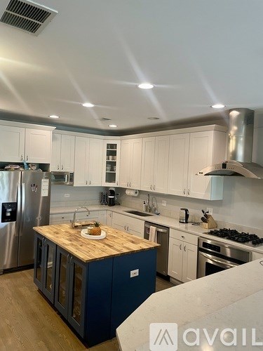 A kitchen with a wooden island in the middle.