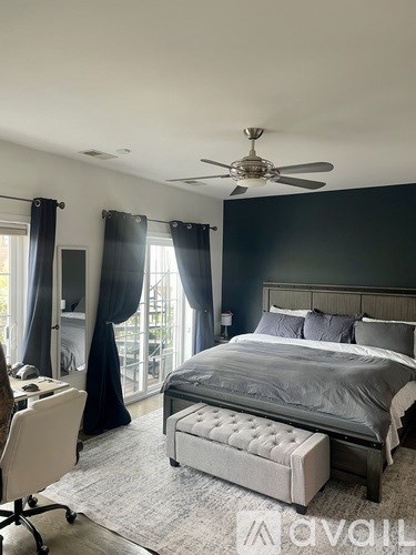 A bedroom with a large bed and a ceiling fan.
