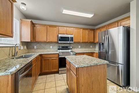 A kitchen with wooden cabinets and granite countertops.