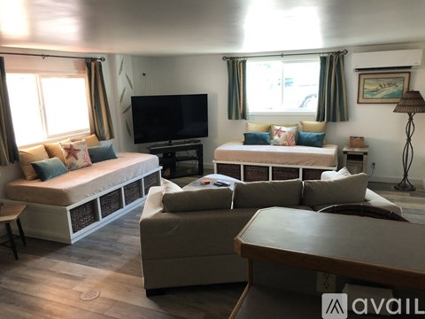 A living room with a television, two couches, and a coffee table.