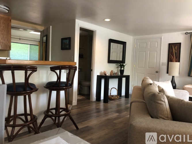 A living room with a couch, two chairs, and a table.