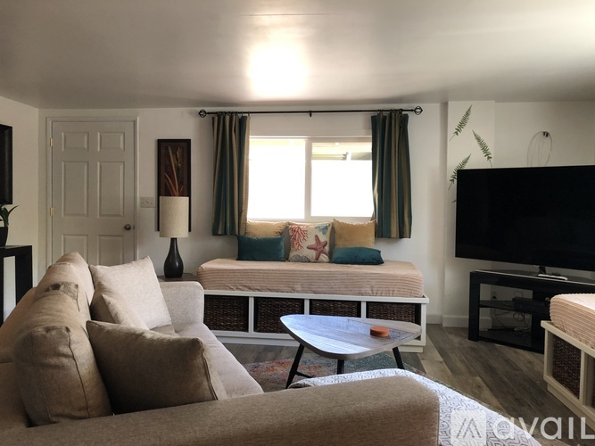 A living room with a couch, a sofa, a table, and a television.