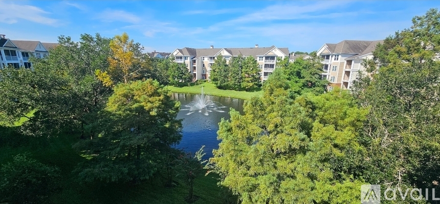 A bird's eye view of a residential area with a lake and trees.