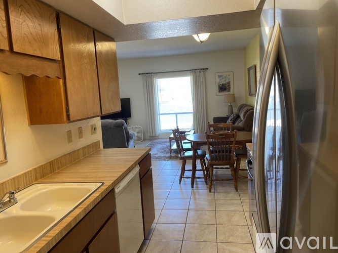 A kitchen with wooden cabinets and a white sink.