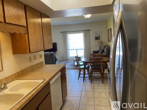 A kitchen with wooden cabinets and a white sink.
