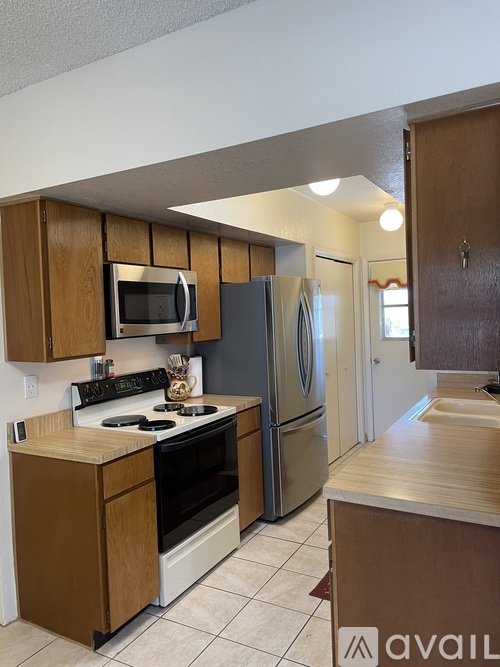 A kitchen with wooden cabinets and a refrigerator.