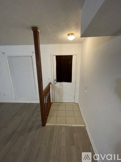 A room with a white door and a brown railing.