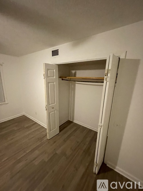 A room with a white door and a wooden floor.