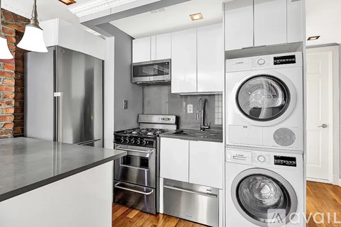 A modern kitchen with stainless steel appliances and white cabinets.