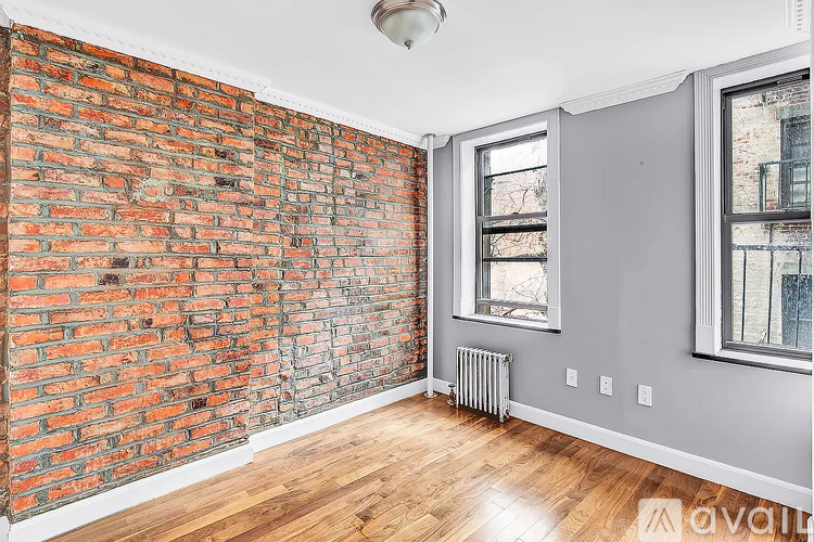 A room with a red brick wall and a window.