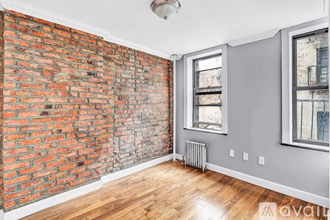 A room with a red brick wall and a window.
