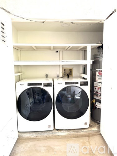 Two front loading washing machines in a small laundry room.