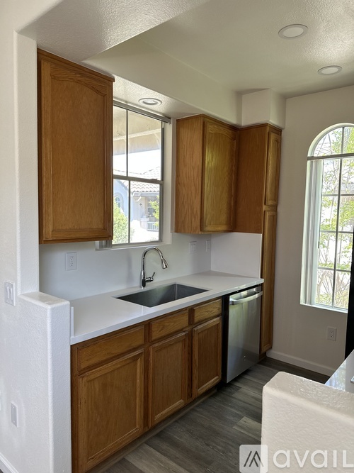 A kitchen with wooden cabinets and a white countertop.