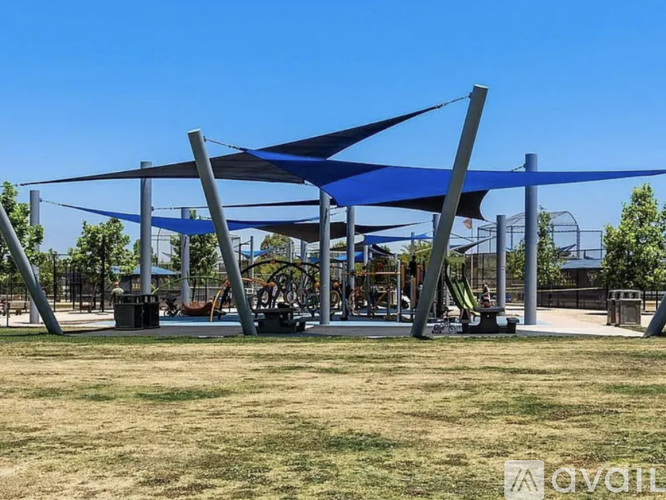 A playground with a blue canopy and a slide.