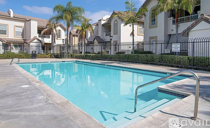 A swimming pool in front of a row of houses.