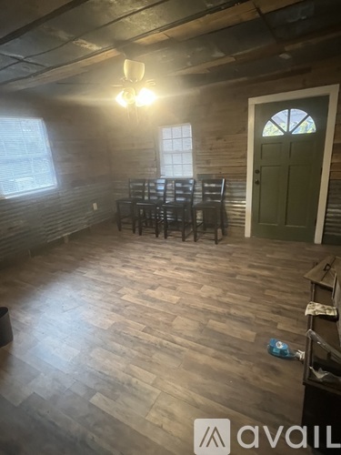 A room with wooden floors and a green door.
