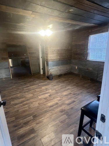 A room with wooden flooring and a bar stool.