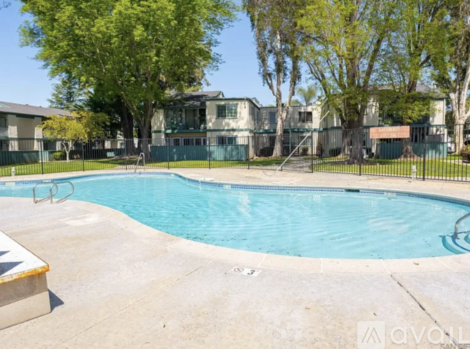 A swimming pool surrounded by a fence and trees.