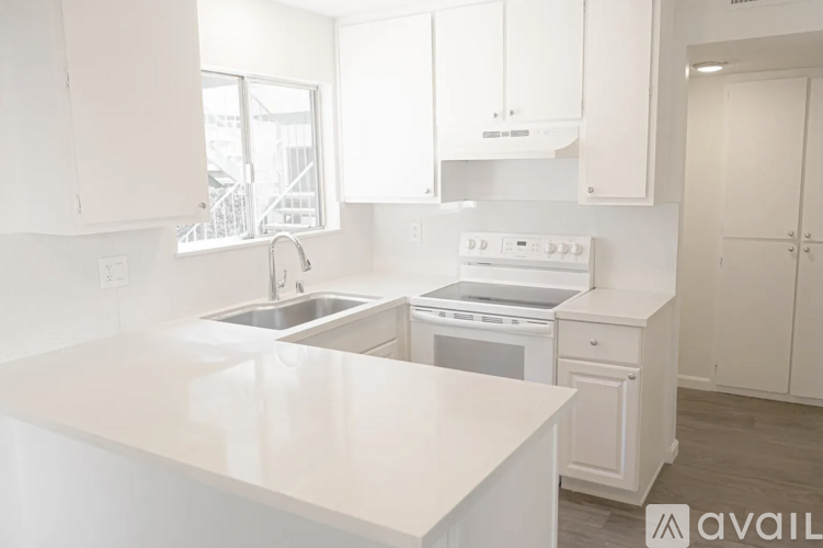 A kitchen with white appliances and cabinets.