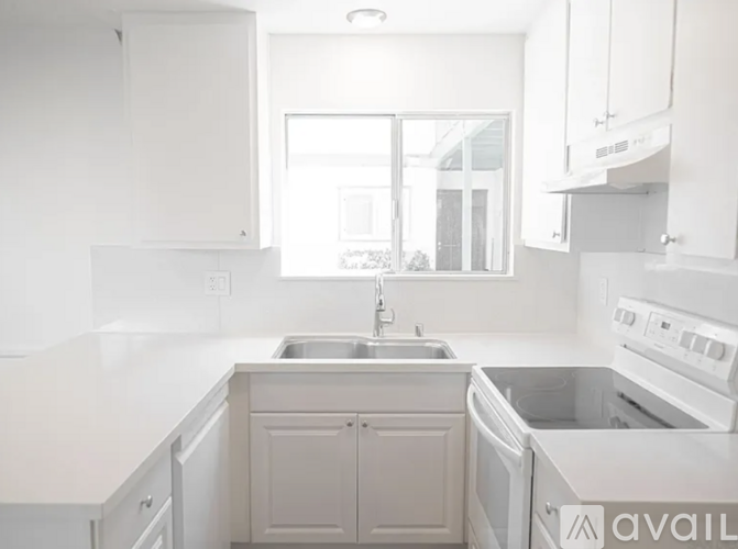 A kitchen with white cabinets and appliances.