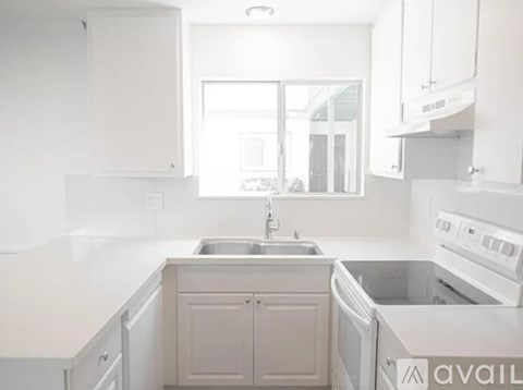 A kitchen with white cabinets and appliances.