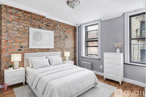 A bedroom with a brick wall and a large bed.