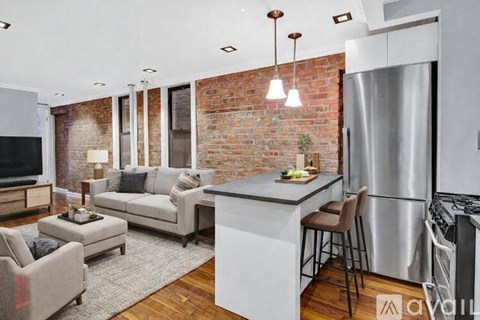 A modern kitchen with a brick wall and a bar area.