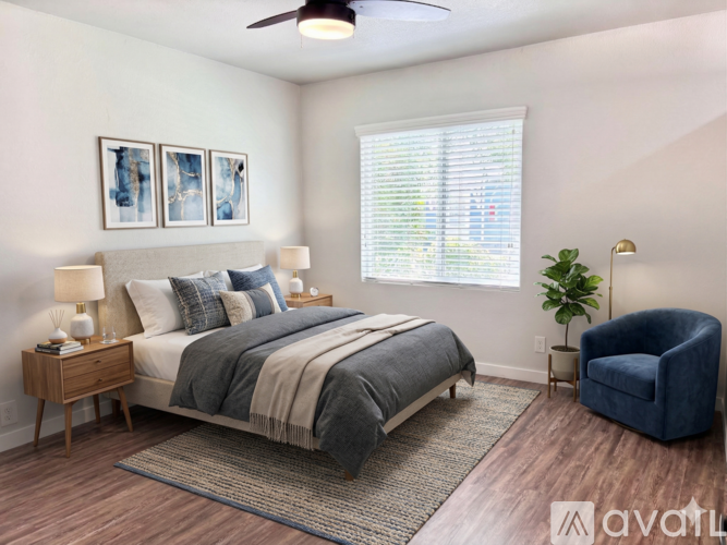 A bedroom with a bed, a chair, and a ceiling fan.