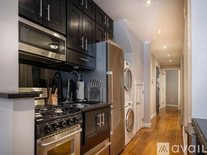 A kitchen with a stove top oven and a refrigerator.