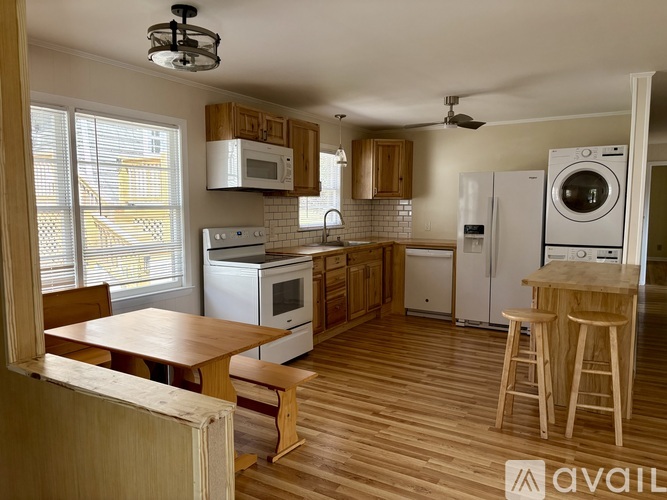A kitchen with wooden floors and white appliances.