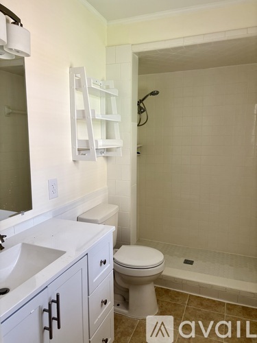 A white toilet sits in a bathroom next to a walk-in shower.