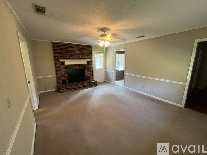 A living room with a fireplace and a ceiling fan.