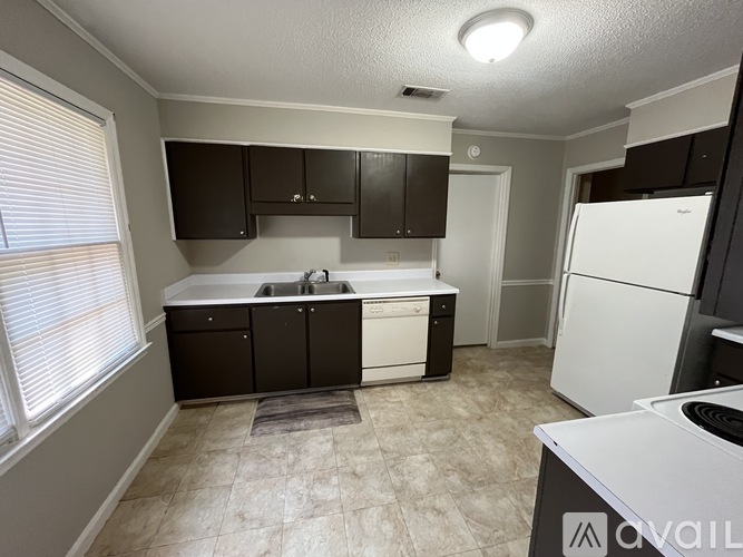 A kitchen with black cabinets and a white dishwasher.