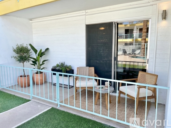 A balcony with a table and chairs overlooking a pool.