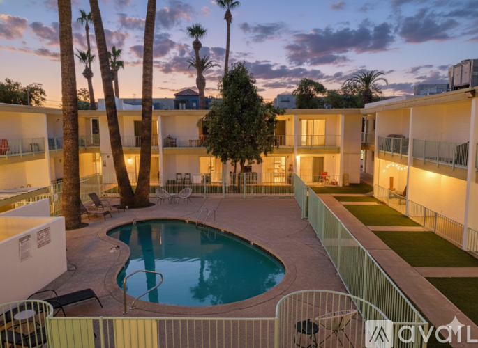 A pool surrounded by a fence and palm trees.