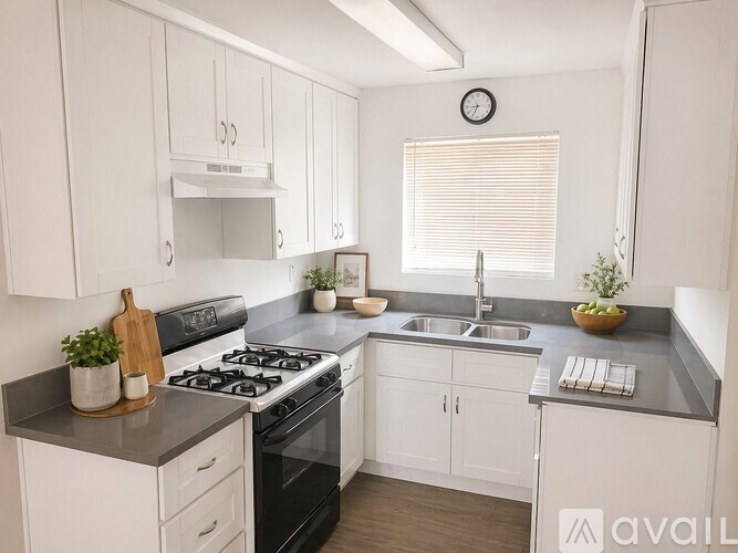 A kitchen with a black stove top oven and white cabinets.