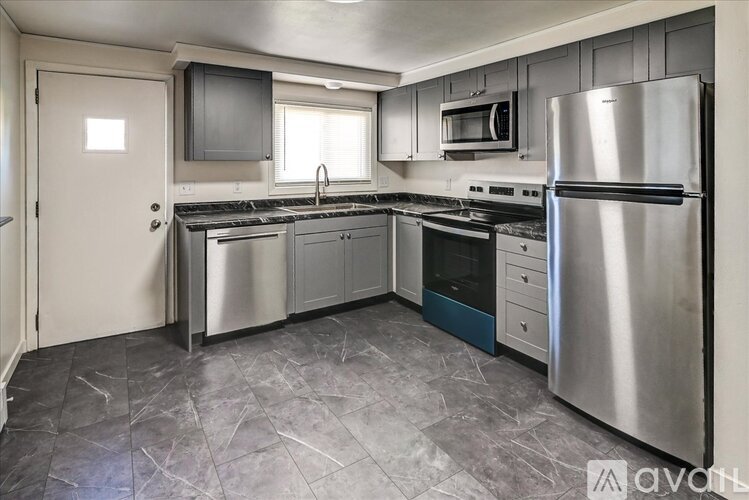 A kitchen with a stainless steel refrigerator and a marble floor.