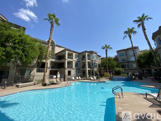 A swimming pool surrounded by palm trees and apartment buildings.