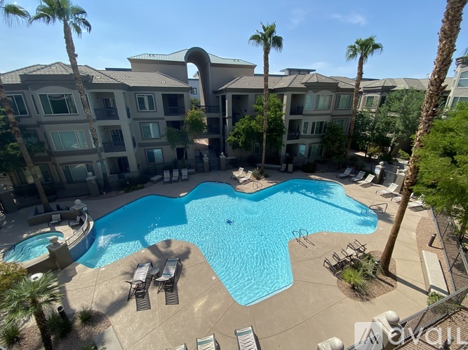 A large swimming pool in the middle of a resort surrounded by palm trees.