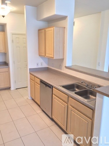 A kitchen with wooden cabinets and a stainless steel sink.