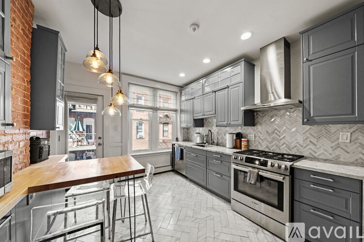 A modern kitchen with a brick wall and a wooden island.